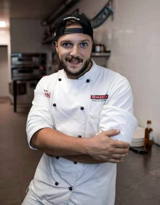 Chef schneidet perfekt gebackene Pizza