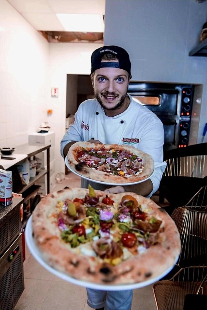 Chef Andrei presenting freshly prepared authentic pizzas